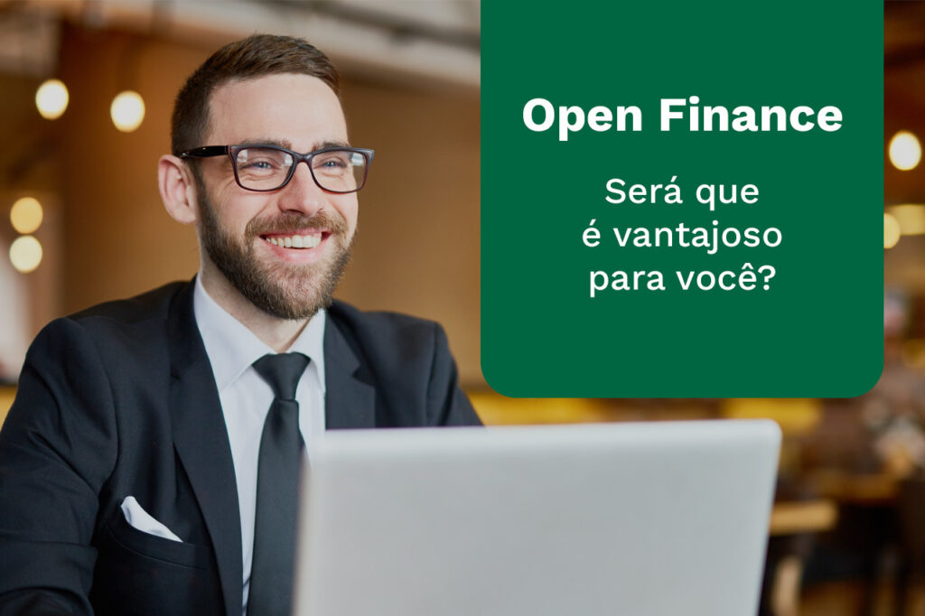 Homem sorrindo de frente para um computador com a frase Open Finance, será que é vantajoso para você?